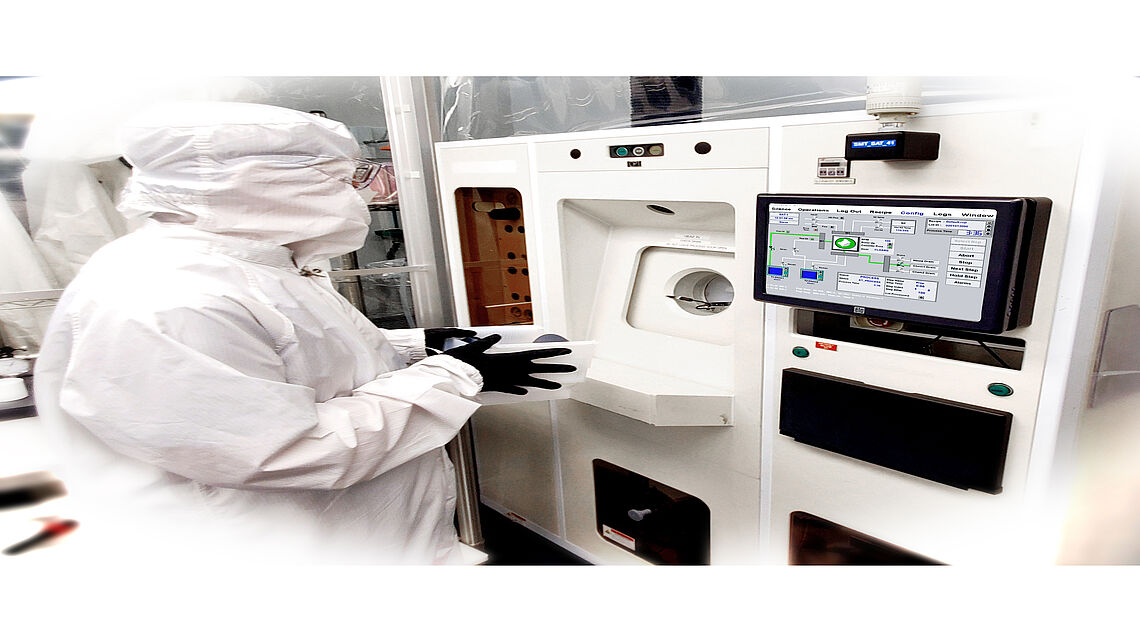 a man at a machine in a protective suit etching process