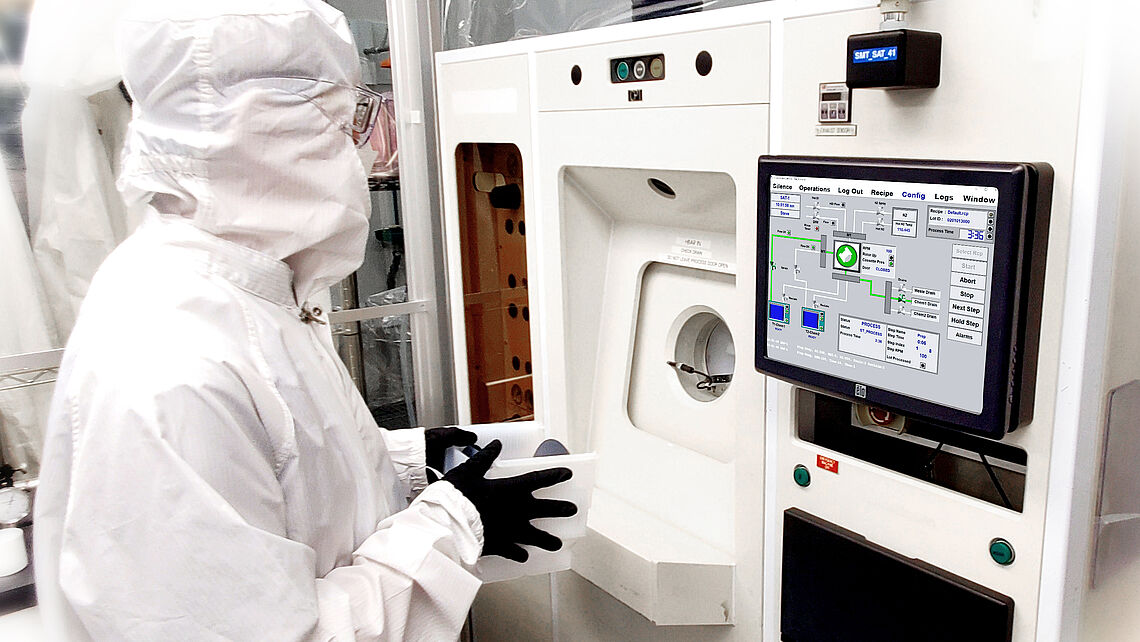 a man at a machine in a protective suit etching process a man at a machine in a protective suit etching process