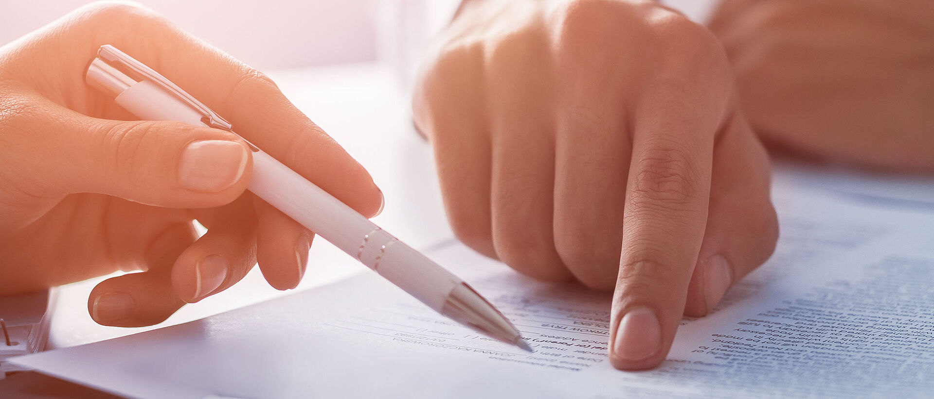 a finger and a pencil pointing at a text